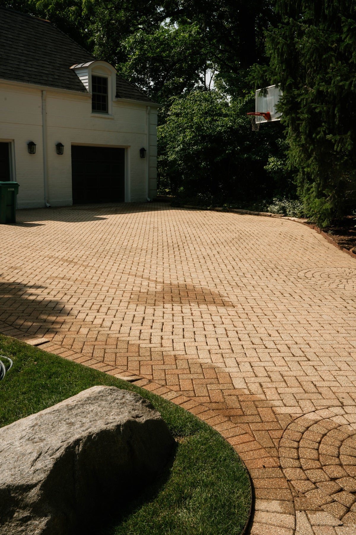 Brick paver driveway beside a detached garage