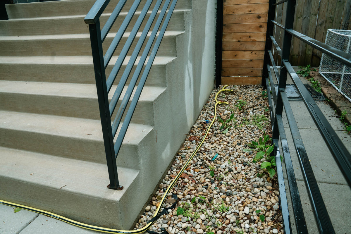 Concrete entrance steps with black railings