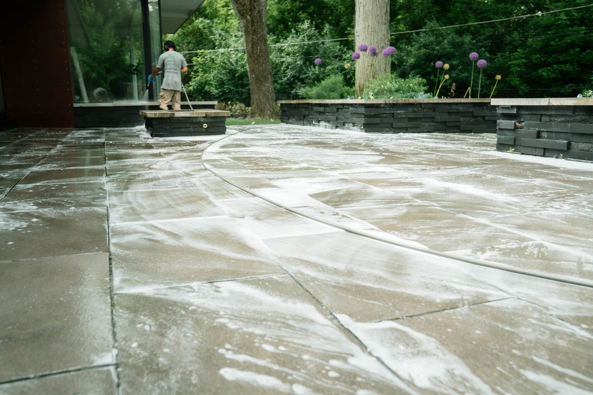 HBP team washing a stone patio outside a modern home