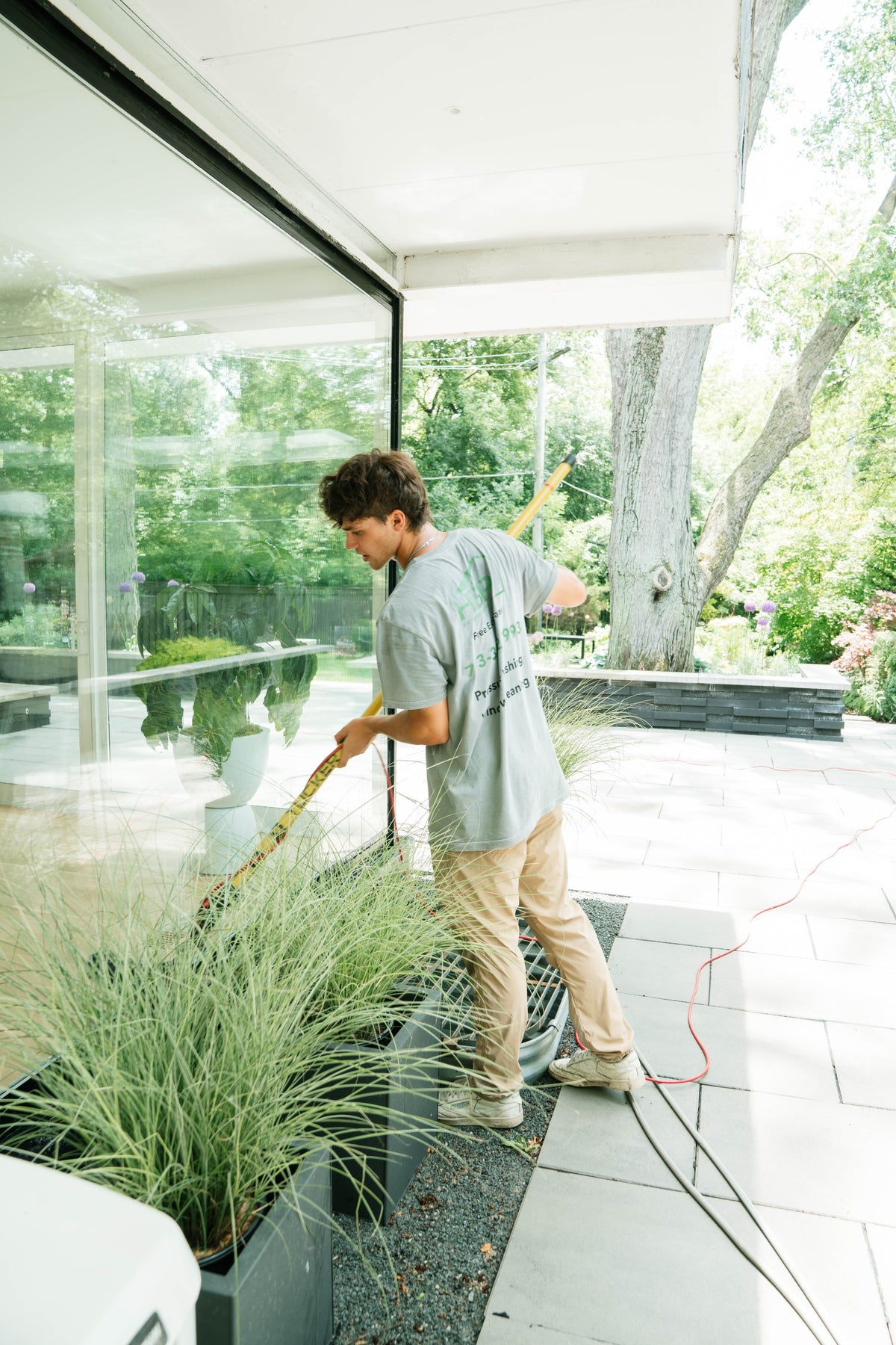 HBP window cleaner working beside a planted patio
